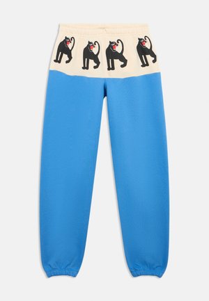 Pantalones de chándal azul con una cinturilla elástica que presenta una banda crema decorada con ilustraciones de gatos negros y acentos rojos en las bocas.