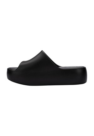 Sandal nero con finitura liscia e opaca. Presenta un design con punta aperta e una suola spessa e arrotondata. Forma semplice e minimalista.