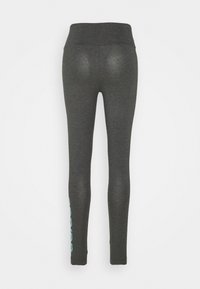 Grå leggings med hög midja, med en slät yta och en grafisk accent i ljusblått längs det vänstra benet.