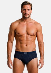 Slip da uomo blu navy con texture a coste e design aderente. Presentano una vita con logo e uno stile minimalista.
