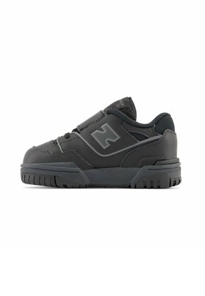 Chaussure de sport noire avec une tige en synthétique, un col rembourré et une semelle extérieure en caoutchouc. Présente un design texturé et une zone de orteil renforcée.