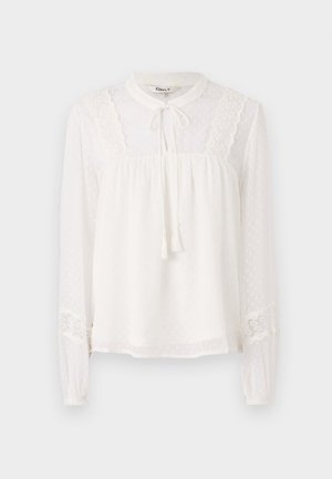 Bela bluza z dolgimi rokavi in visokim ovratnikom, okrašena z čipkastimi detajli in vrvico za zategovanje; ima teksturirane pikice po tkanini.