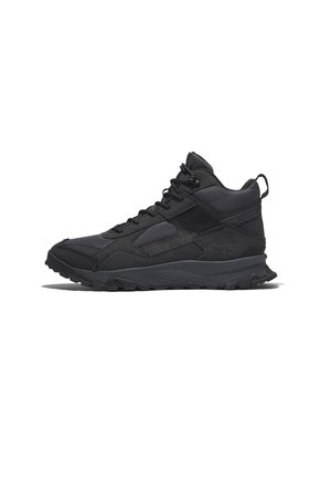 Zapatillas de senderismo de caña media negras que presentan una combinación de materiales texturizados y lisos, suela de goma duradera y una lengüeta trasera.