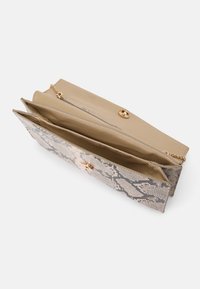 Kabelka s hadím vzorem, beige interiér. Má zlaté zapínání na patent a řetízek na nošení. Kompaktní a strukturovaný design.