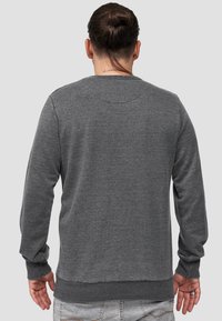 Felpa grigia con maniche lunghe, colletto rotondo, polsini e orlo a costine. Realizzata in tessuto morbido, presenta un design semplice senza fantasie.