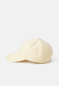 Yellow baseball cap with a curved brim, stitched details, and ventilation holes on the sides. Features a logo on the front.