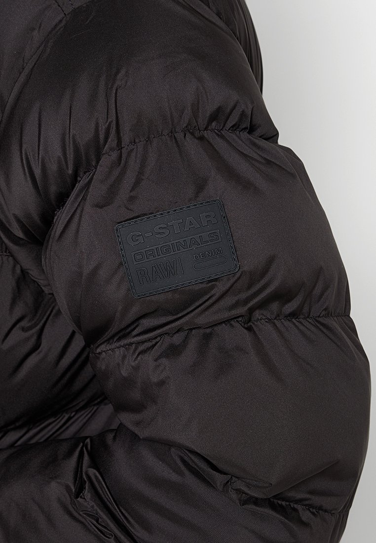 Schwarze Steppjacke mit strukturiertem Material, ausgestattet mit einem rechteckigen G-Star Originals-Logo-Patch auf dem oberen Ärmel.