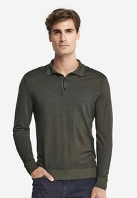 Mörkgrön långärmad polo skjorta tillverkad av ett mjukt sträckt tyg, med krage, tre knappslå och ribbad mudd.