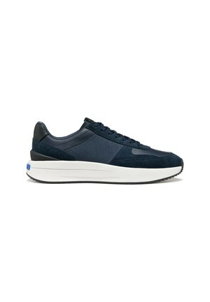 Basket basse bleu marine avec dessus en tissu texturé mélangé, semelle blanche épaisse et accents noirs au niveau du talon et des lacets, vue de profil.