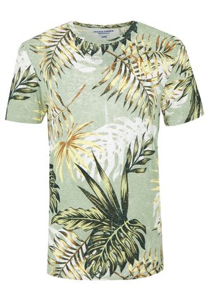Zielony t-shirt z krótkim rękawem z tropikalnym wzorem liści w kolorach żółtym, czarnym i białym, z okrągłym dekoltem i luźnym krojem.