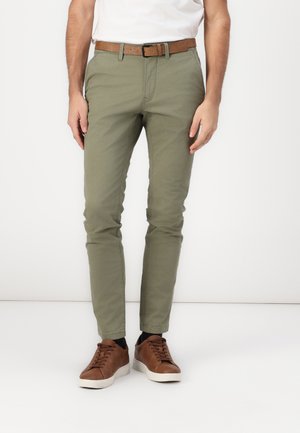 Chinos verde oliva con un corte ajustado, hechos de tela de algodón, combinados con un cinturón de cuero marrón y zapatillas marrones. Textura suave, sin patrones.