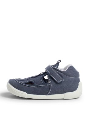 Blå stofsko med lukket tå og åbne sider, med en Velcro-strop og hvid gummisål. Detailleret syning langs sømmene.