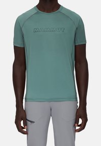 Light green short-sleeve T-shirt with a rounded neckline, featuring a bold "MAMMUT" logo printed across the chest and contrasting stitching.