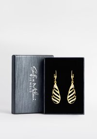 Orecchini a spirale in oro con un design vorticoso e gemme trasparenti incorporate, presentati in una scatola foderata in velluto nero con un logo argentato.
