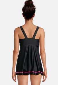 Zwarte zwemjurk met een uitlopende ontwerp, voorzien van brede bandjes, een roze accent aan de zoom en een gladde, gestructureerde stof. Achteraanzicht weergegeven.