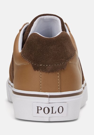 Καφέ δερμάτινο αθλητικό παπούτσι με σουέτ λεπτομέρειες στη φτέρνα, λευκή σόλα και λευκές ραφές. Διαθέτει εμφανή ετικέτα "POLO" στην πίσω πλευρά.