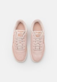 Zapatillas de ante rosa suave con forma redondeada, forro de tela, puntera perforada y logotipo embosado en la lengüeta y en el lateral.