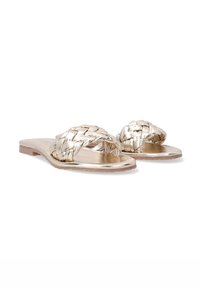 Metallisch goldene flache Sandalen mit geflochtenen Riemen, flachen Sohlen und glatter Textur. Offene Zehenform geeignet für lässige Trageweise.