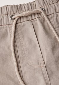Beige snören shorts med elastisk midja, med en subtil textur, sidoficka och kontrasterande randig snörning.