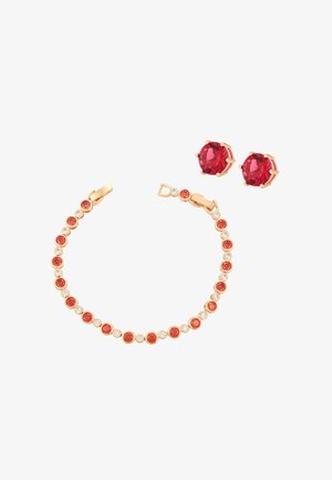 Arany karkötő váltakozó kis piros és fehér drágakövekkel, hozzá illő, kerek piros drágakő fülbevalókkal párosítva.