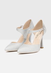 Scarpe con tacco alto in argento glitterato, con punta affusolata, cinturino alla caviglia e tacco a blocco trasparente. Le scarpe presentano un design con tagli sui lati.