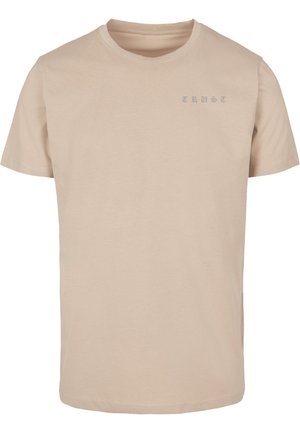 T-shirt en coton beige à manches courtes. Présente le mot "CONFIANCE" en lettres bleu clair sur le côté gauche supérieur. Design simple, coupe standard.