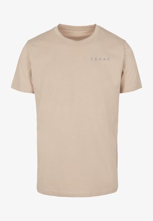 Beige katoenen t-shirt met korte mouwen. Heeft het woord "TRUST" in lichtblauwe letters op de bovenlinkerkant. Eenvoudig ontwerp, standaard snit.