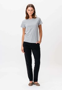 Grå t-shirt med korte ærmer lavet af bomuld, parret med sorte slim-fit bukser, præsenteret med en neutral baggrund. Simpelt design og komfortabel pasform.