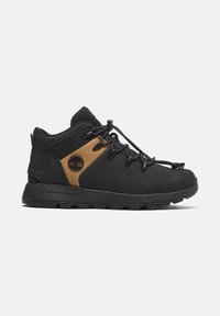 Chaussure de randonnée noire et brune avec une languette rembourrée, une semelle en caoutchouc et un design à lacets. Présente un logo sur le côté et des accents texturés.
