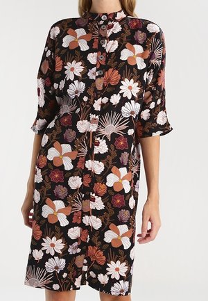 Robe noire mi-longue avec imprimé floral large en blanc, orange et bordeaux, boutonnée à l'avant et manches trois-quarts.