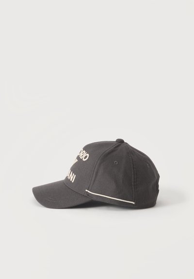Casquette de baseball gris foncé avec texte blanc brodé partiellement visible, avec des trous de ventilation cousus et une visière incurvée.