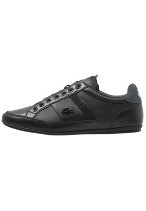 Black Lacoste low-top sneaker with leather and mesh panels, lace-up front, and crocodile logo on side.