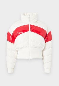 Zkrácená puffer bunda v bílé barvě s lesklými červenými diagonálními pruhy. Má vysoký límec, zapínání na zip a žebrované manžety a lem.