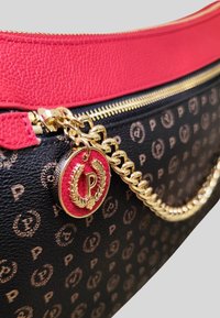 Borsa nera con motivo e cerniera dorata, caratterizzata da una medaglia rossa e dorata con una "P" e un emblema di corona d'alloro.