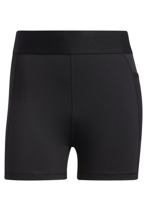Kobieta nosząca czarny sportowy biustonosz, czarną bluzę z kapturem na zamek, czarne spodenki rowerowe i czarne sneakersy Adidas, pokazana od ramion do stóp.