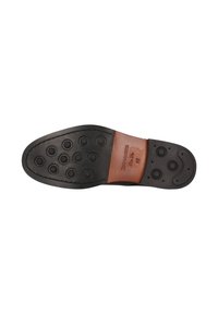 Sole in gomma nera con motivo di battistrada circolare e finiture in pelle beige. Dettagli del marchio incisi visibili sulla sezione in pelle vicino al tallone.