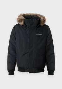 Μαύρη μονωμένη ζακέτα με κουκούλα επενδεδυμένη με γούνα, δύο μπροστινές τσέπες, ribbed μανίκια και λογότυπο στο στήθος. Διαθέτει κλείσιμο με φερμουάρ.