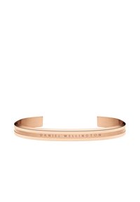 Rožu zelta aproce ar pulētu apdari, kas sastāv no divām paralēlām joslām un uz vienas puses ir iegravēts "DANIEL WELLINGTON".