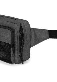 Marsupio in tessuto grigio con pannello testurizzato, scomparti con zip e tracolla regolabile. Presenta accessori neri e una patch con logo.