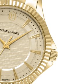 Guldbelagd armbandsur med en strukturerad krämfärgad urtavla med vågmönster, guldvisare och en strukturerad bezel. Varumärket "Pierre Lannier" visas.