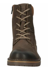 Brown leather ankle boot with a black rubber toe cap, contrasting tan stitching, and metal eyelets for laces. Features a side zipper.