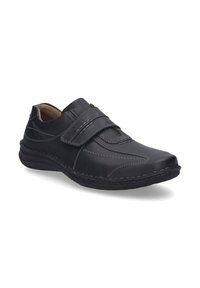 Zapato de cuero negro con dos correas ajustables de Velcro, costuras en contraste, puntera redondeada y suela texturizada para mayor agarre y comodidad.