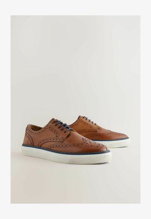 Chaussures en cuir marron avec un design perforé, lacets bleus et semelles en caoutchouc blanches. Silhouette basse avec des accents de couture détaillés.