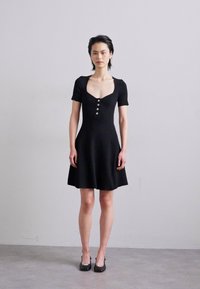 Rochie neagră cu mânecă scurtă, cu un corp ajustat și fustă evazată. Prezintă un decolteu pătrat și detalii cu nasturi pe toată lungimea frontală. Textură netedă.