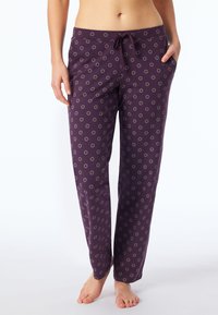 Lila pyjamasbyxor med dragsko i midjan, prydda med ett mönster av små cirkelmönster i guld. Tillverkade av ett mjukt, lätt tyg.