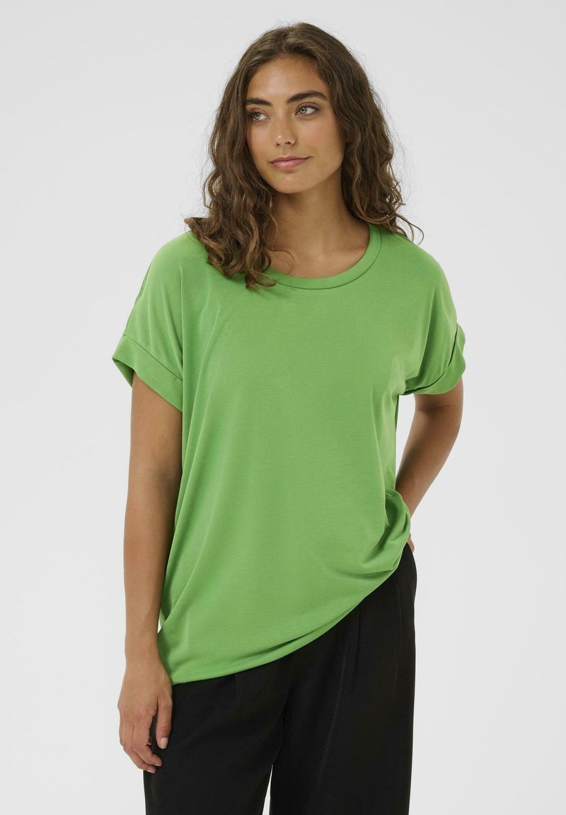 Groen T-shirt met korte mouwen, gemaakt van gladde stof met een losse pasvorm, ronde hals en opgerolde mouwomslag, gecombineerd met zwarte broek.