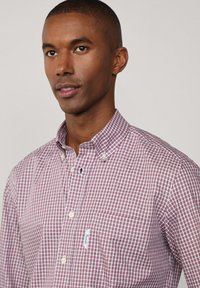 Camicia a quadri in tonalità di bordeaux e bianco, con colletto button-down, maniche lunghe e taschino sul petto con etichetta del marchio.