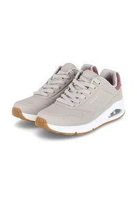 Zapatillas deportivas Skechers de color gris claro con mediasoles blancos, suelas de goma, cordones en la parte frontal y bolsas de aire acolchadas en el talón.