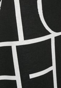 Svart tyg med ett vitt geometriskt rutmönster som har vertikala, horisontella och böjda linjer.