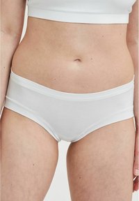 Hvide bomulds hipster trusser med en glat tekstur og elastisk talje. Enkel design uden mønstre eller accenter.